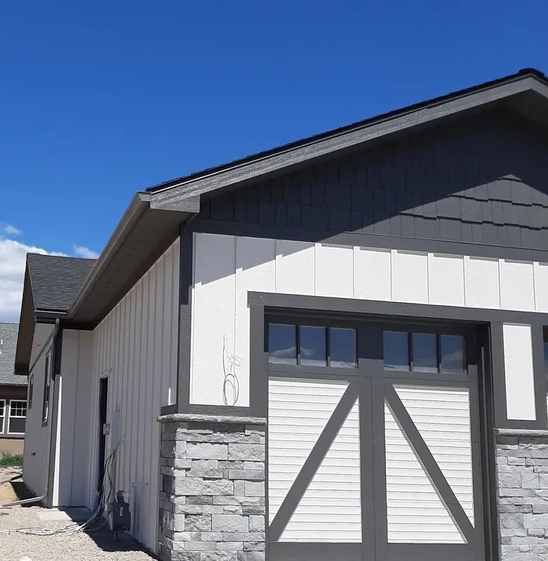 Modern home with dark gutters and stone accents